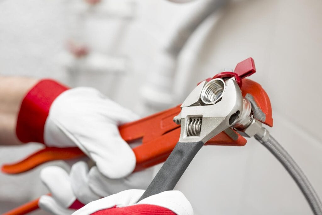 Plumber holding pipe wrenches for an emergency repair in Pembroke Pines
