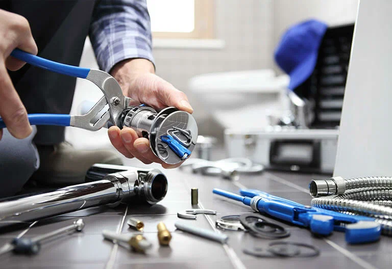 Technician repairing a plumbing fixture with professional tools in Pembroke Pines