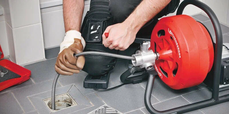 Plumber using a drain-cleaning machine in Pembroke Pines
