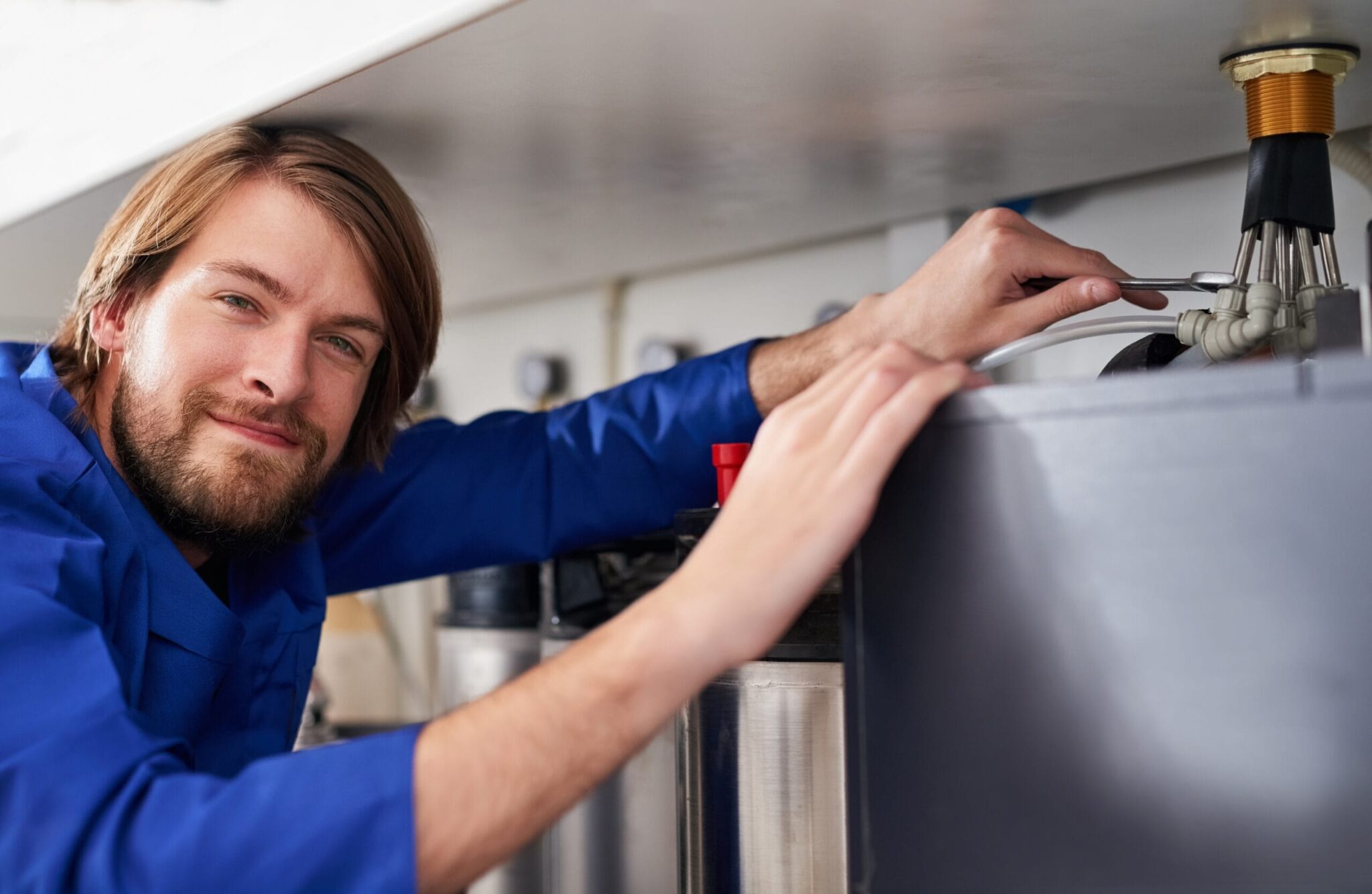 Technician servicing a residential water heater tank in Pembroke Pines